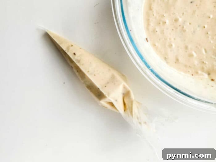 How to Make Funnel Cake Batter - A close-up of smooth funnel cake batter being prepared, highlighting the creamy texture before frying.