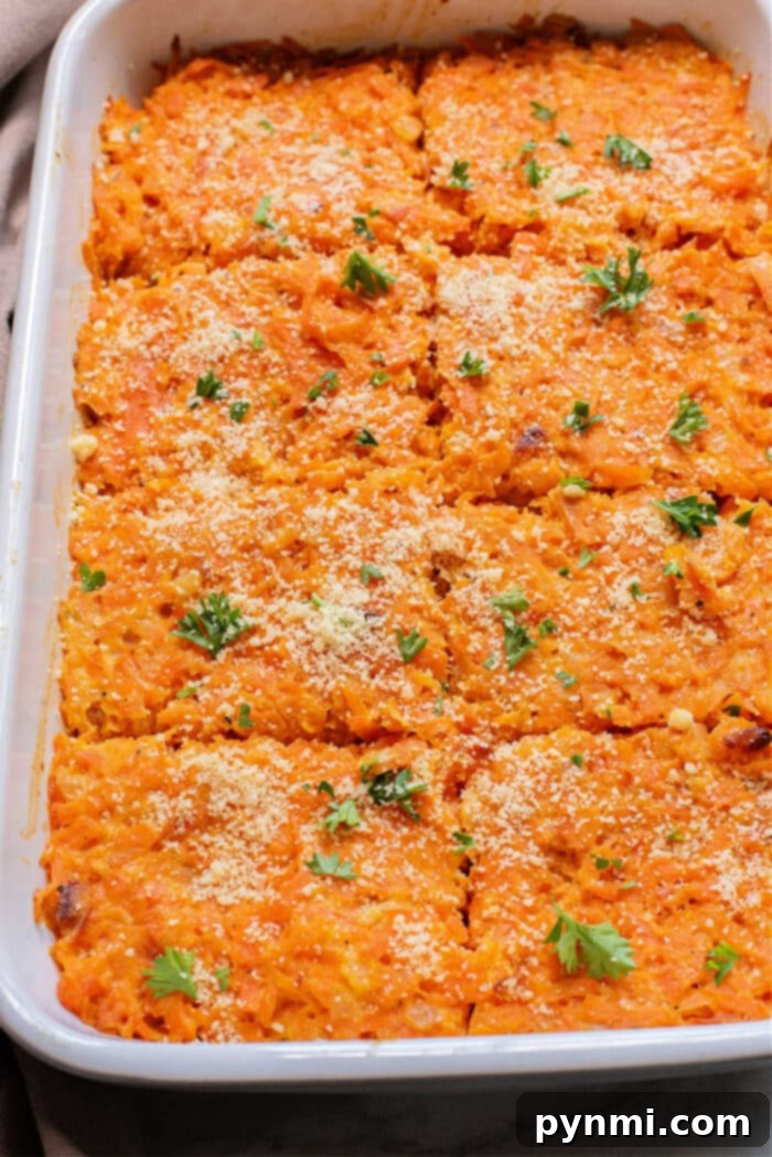 Grandma's Sweet Carrot Bake 2 Baked sweet potato and carrot casserole in a dish, topped with breadcrumbs and fresh herbs, cut into square portions.