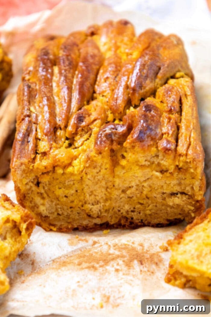 Braided Pumpkin Yeast Bread in a loaf pan, sliced to show the swirl
