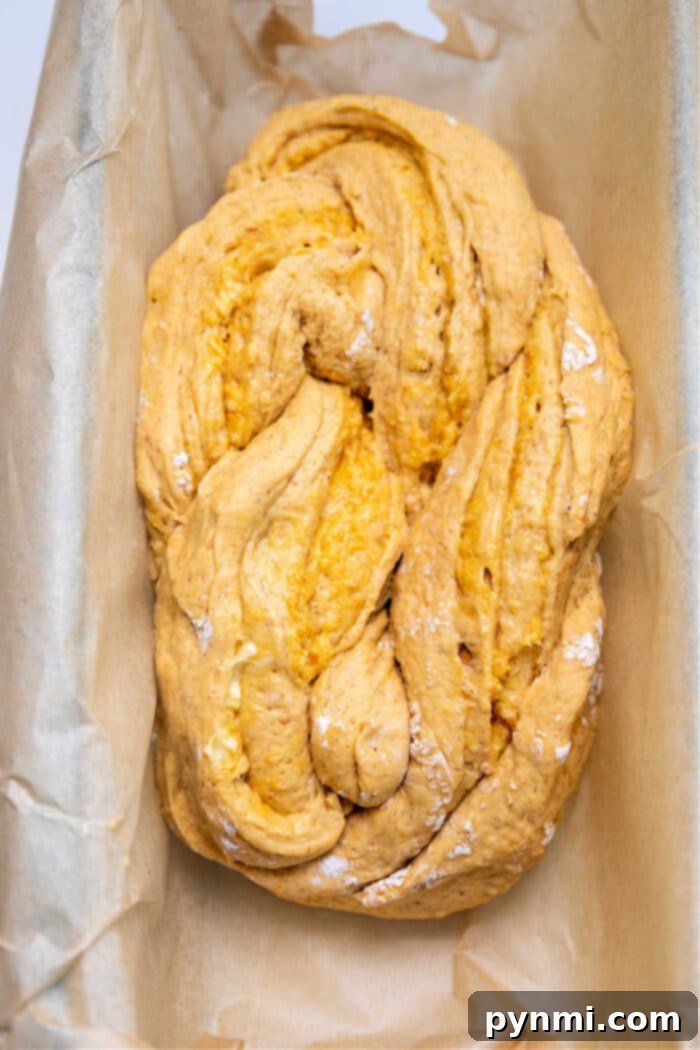Freshly baked braided pumpkin bread on a cooling rack