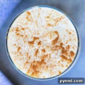 Top view of a creamy drink in a glass, sprinkled with cinnamon, infused with pumpkin cream cold foam.