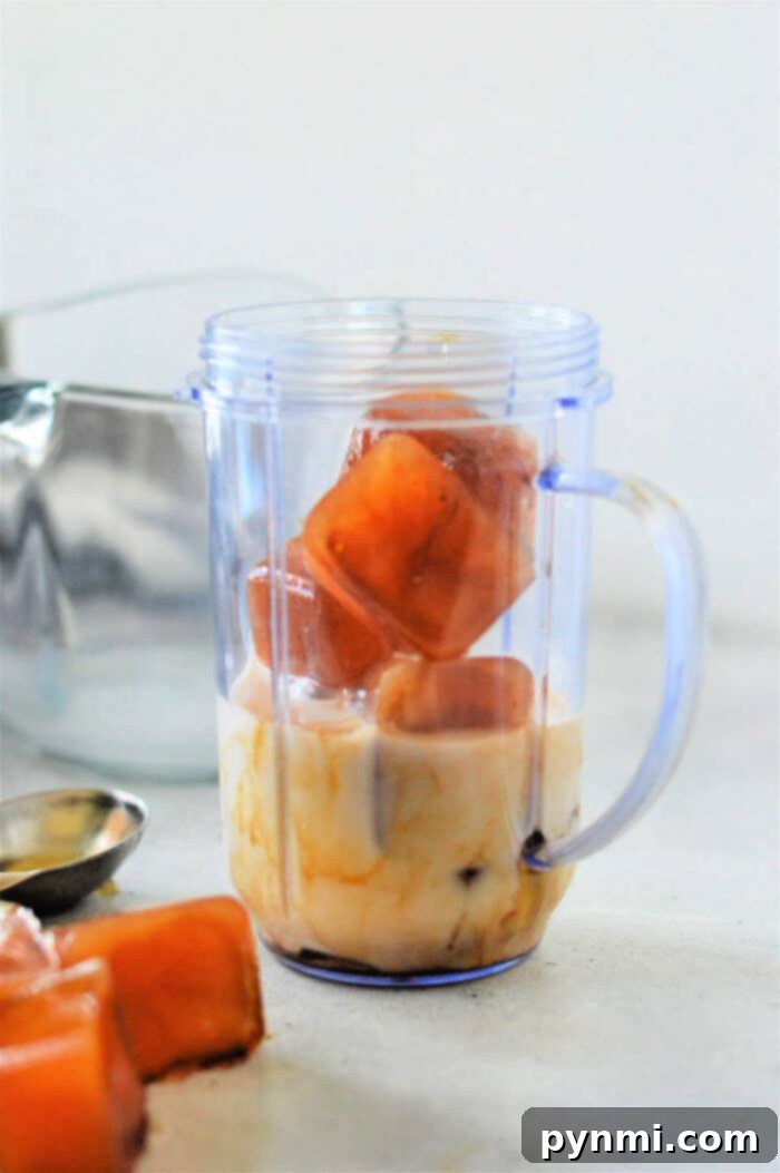 Create Cafe Style Cold Foam At Home 4 Blender cup with milk and coffee ice cubes, ready for cold foam