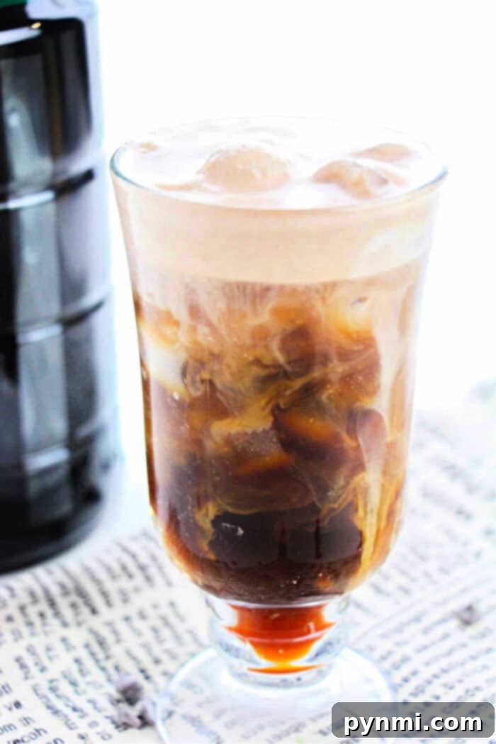 Create Cafe Style Cold Foam At Home 6 Iced coffee with frothy cold foam on a newspaper background