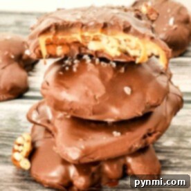 Decadent Pecan Caramel Bites 4 A stack of chocolate-covered caramel and pecan turtles, with one showing a bite revealing the caramel and pecans. They are sprinkled with sea salt and presented on a wooden board.