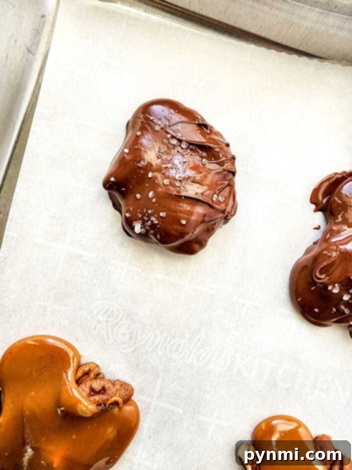 Decadent Pecan Caramel Bites 5 Clusters of caramel and pecans, ready to be dipped in chocolate, resembling turtle shapes.
