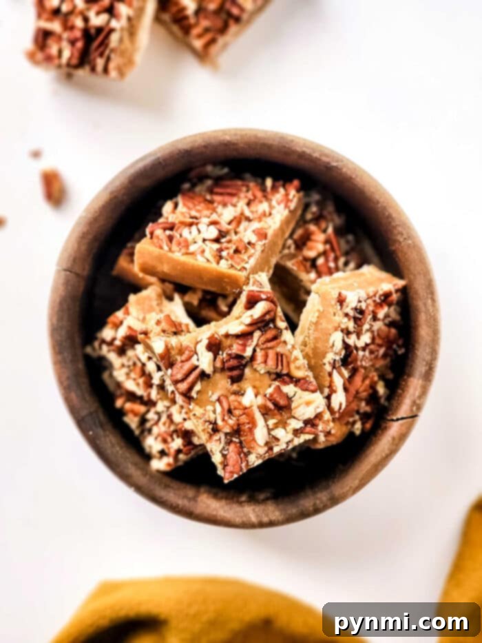 Close-up of a stack of buttery maple pecan fudge squares on a plate