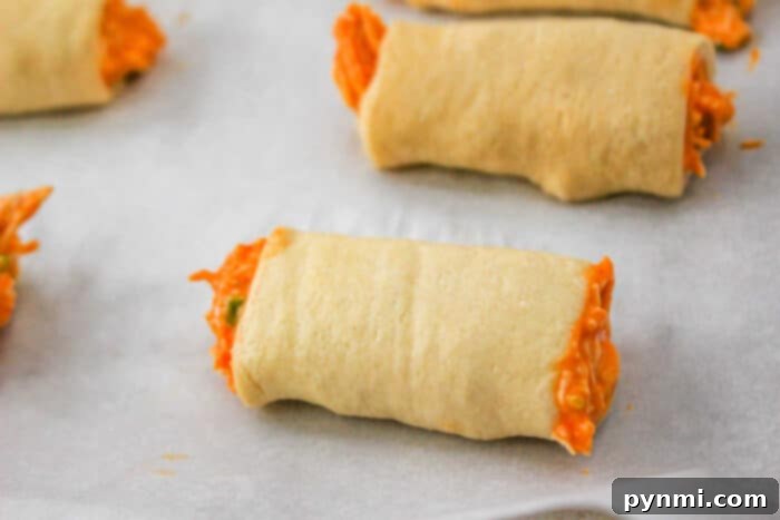 A single, perfectly baked Buffalo Chicken Roll, showcasing its golden-brown crust and a hint of the delicious filling peeking out.