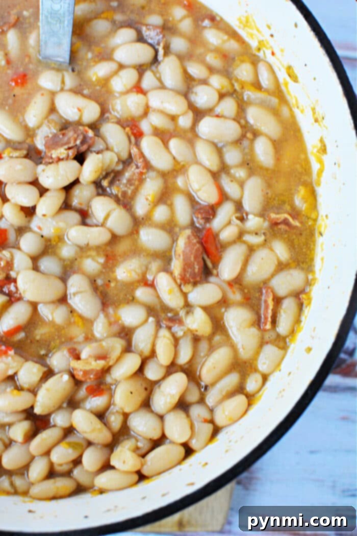 A pot of Peruvian Beans simmering on the stove, rich with broth and seasonings