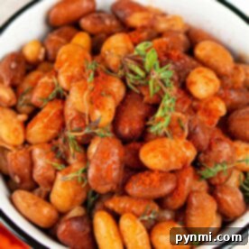 A bowl of seasoned roasted tepary beans garnished with fresh herbs.