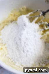 Cool Peppermint Cloud 7 A mixer delicately blends flour and butter in a white bowl, setting the stage for the creation of a delightful dessert topped with creamy peppermint frosting.