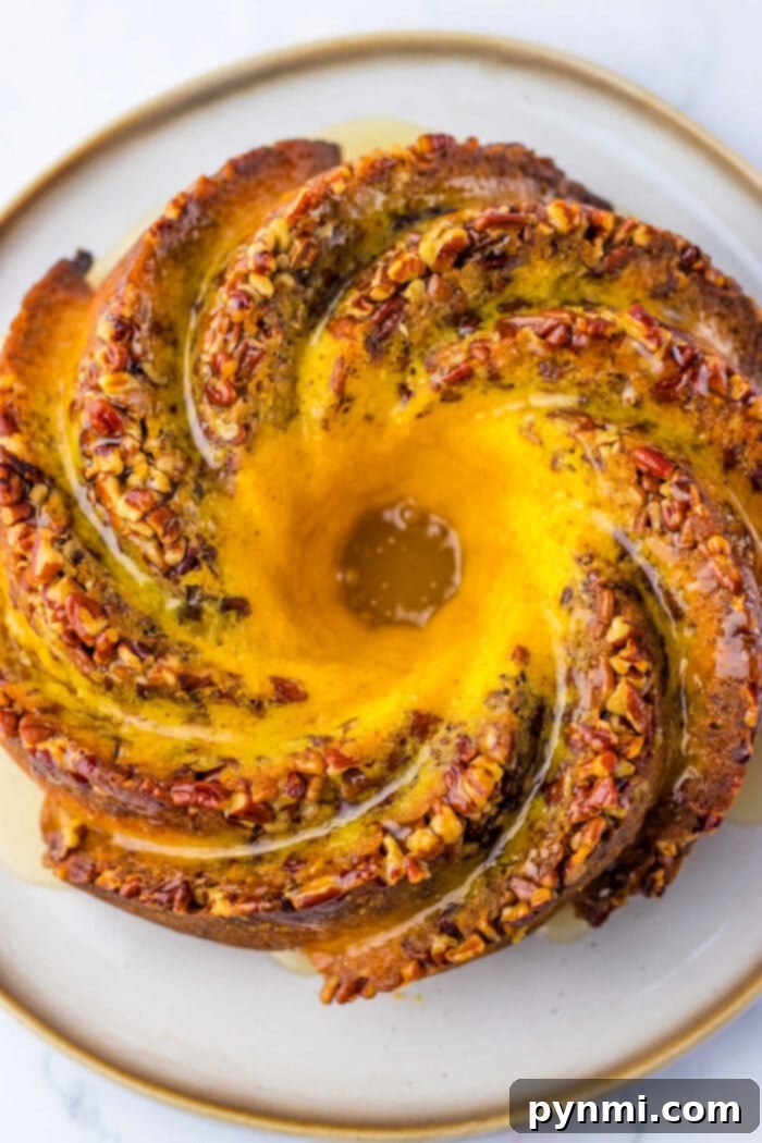 A stunning Pecan Bundt Cake, golden brown and drizzled with a rich glaze, hinting at the deliciousness within.