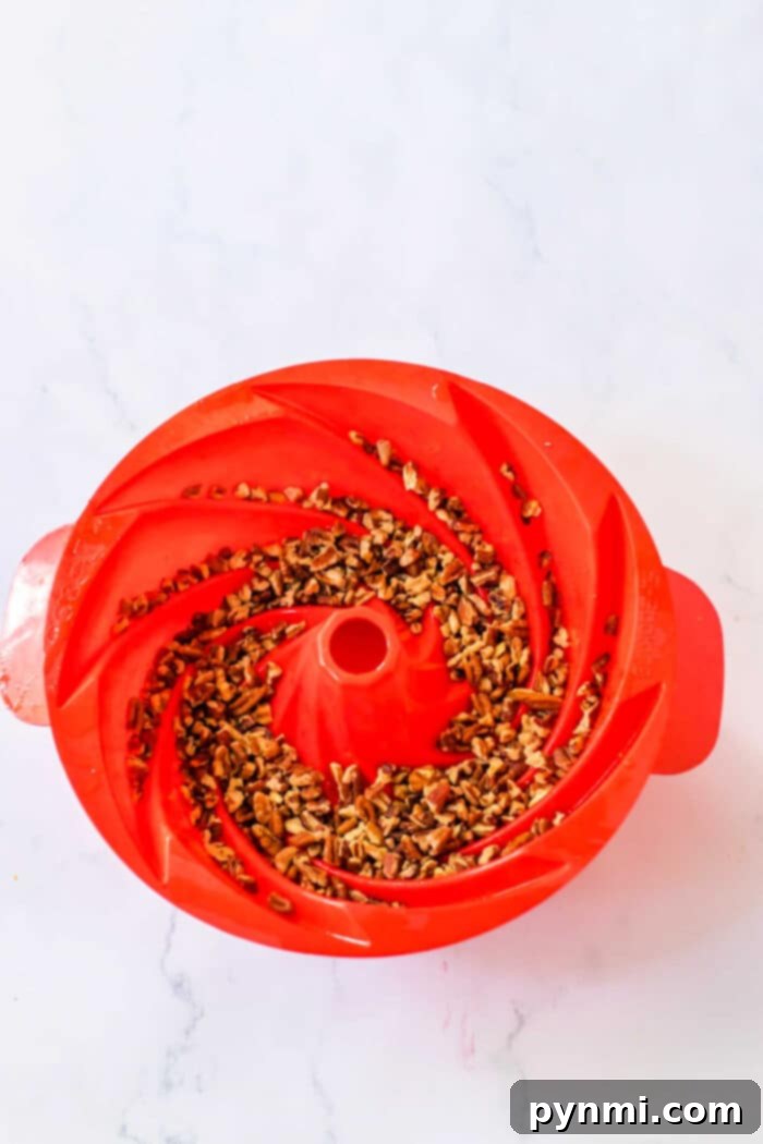 A delicious Bundt Cake, generously studded with nuts and drizzled with glaze, captured in an inviting close-up, promises a delightful culinary experience.
