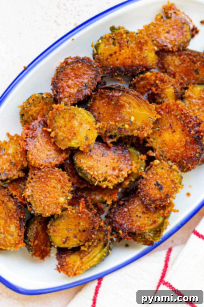 Crispy, golden-brown Parmesan Brussels served on a white plate with a blue rim.