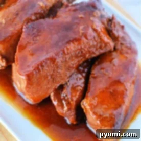 Homestyle Slow Cooker Country Ribs 7 Slow cooker country-style ribs with liquid smoke and barbecue sauce on a white platter.