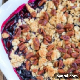 Beyond Potatoes What Defines Idaho 7 Huckleberry cobbler topped with oat crumble and pecans in a white baking dish.