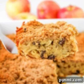 A perfect slice of apple kugel with a golden, crispy topping being lifted from a baking dish