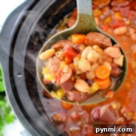 A ladle scoops hearty 15 Bean Soup with sausage from a crock pot.