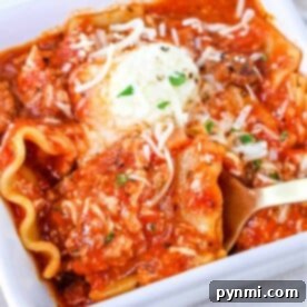 A close-up of one pot lasagna soup in a white dish, topped with melted cheese and herbs.