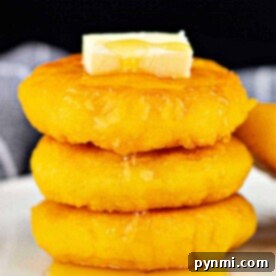 Kettle Cornbread Comfort 7 A tempting stack of hot water cornbread cakes, perfectly golden and crowned with butter, drizzled generously with syrup on a pristine white plate.