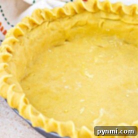 Unbaked shortbread pie crust in a pan with fluted edges