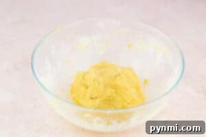 Buttery Shortbread Pie Crust 7 A clear glass bowl with a ball of yellow shortbread pie crust dough