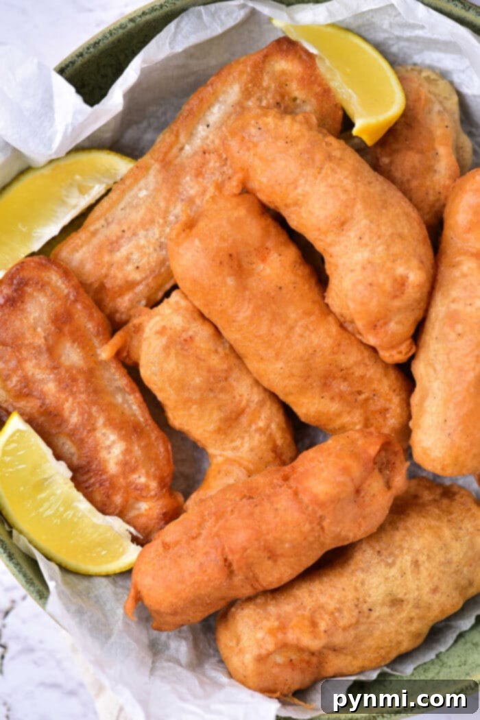 Crispy Ale-Battered Halibut 2 Crispy Beer Battered Halibut served with lemon wedges and sauce.