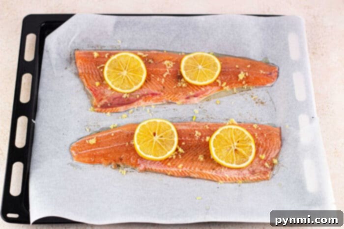 Beautifully seasoned oven-baked trout fillets on a baking sheet
