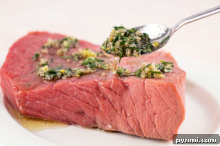 A chef slicing a perfectly cooked beef bottom round roast against the grain.