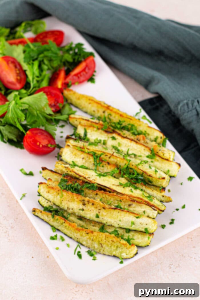Oven roasted zucchini spears with parmesan and herbs, perfectly golden and tender.
