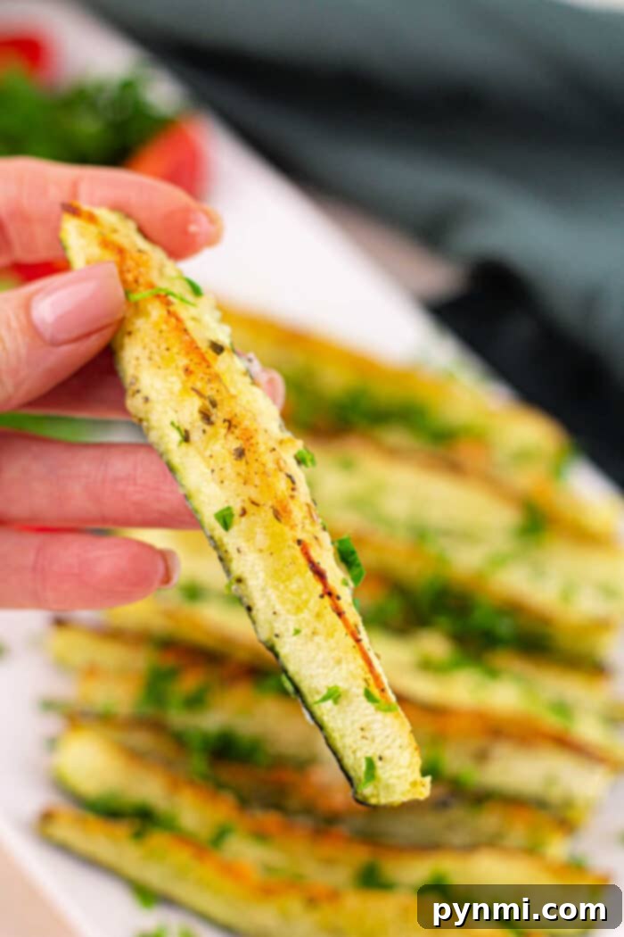 A vibrant display of how long to roast zucchini, featuring perfectly cooked spears on a wooden board.