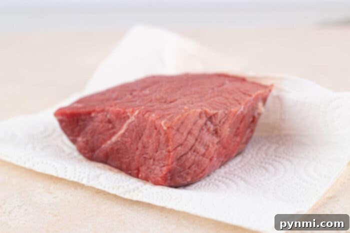 Oven-baked bottom round roast developing a beautiful golden-brown crust.