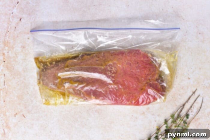 Mastering Chuck Steak 4 Chuck steak soaking in a rich, savory marinade in a bowl.