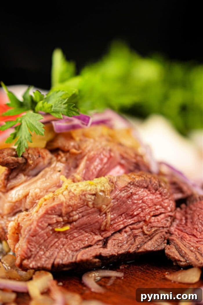 Sliced chuck roll steak with onions and greens