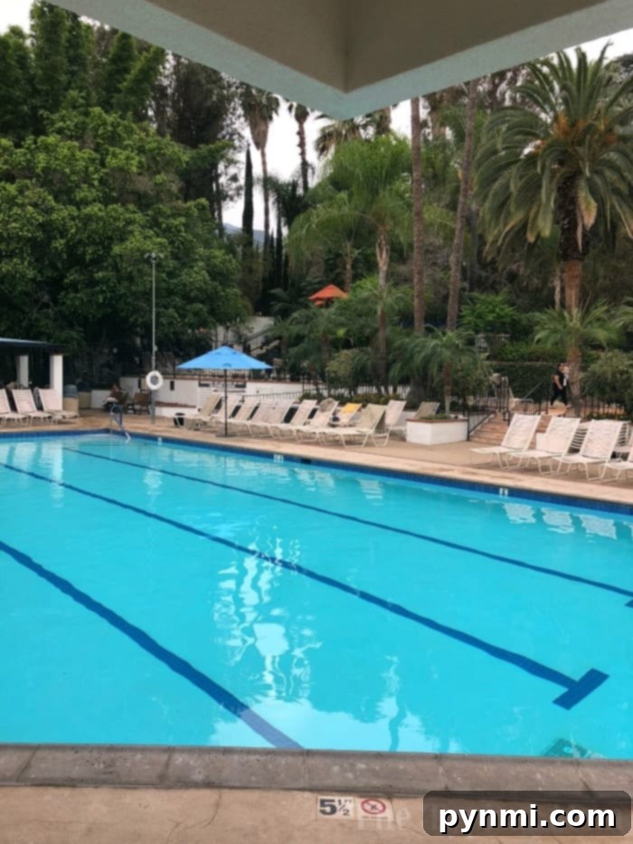 A serene outdoor spa setting at Glen Ivy Hot Springs, featuring comfortable seating areas under shaded structures, surrounded by lush plants, inviting guests to unwind and relax.