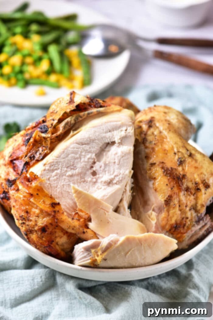 Beer Can Chicken Recipe in Oven: a beautifully roasted chicken on a beer can, served with roasted vegetables in a dish.