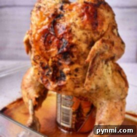 Beer Can Chicken in oven, perfectly roasted on a can in a glass baking dish.