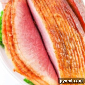 Perfect Oven-Baked Spiral Ham 7 Close-up of a sliced, glazed ham served on a platter with parsley garnish, showcasing the delightful results of how to cook a spiral ham in the oven.