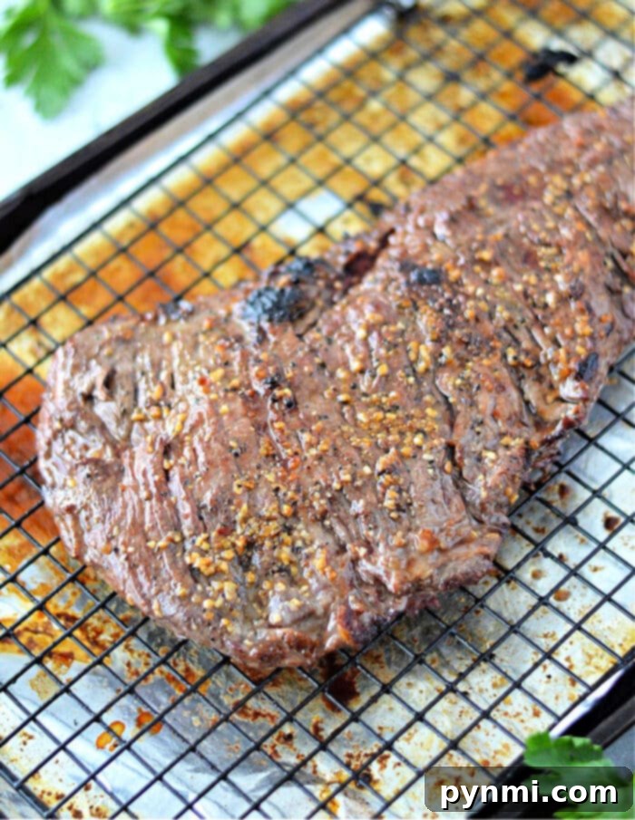 Perfect Oven Skirt Steak Every Time 2 A perfectly broiled skirt steak resting on a wire rack with a savory seasoning on top basks in the warmth of the oven.