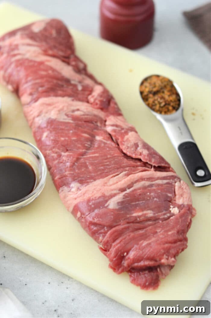 Perfect Oven Skirt Steak Every Time 3 A raw skirt steak rests on the cutting board, ready to become a masterpiece. Alongside it, a bowl of rich soy sauce and a spoonful of spices await their turn to enhance flavors. Imagine preparing skirt steak in the oven with this selection for an unforgettable culinary experience.