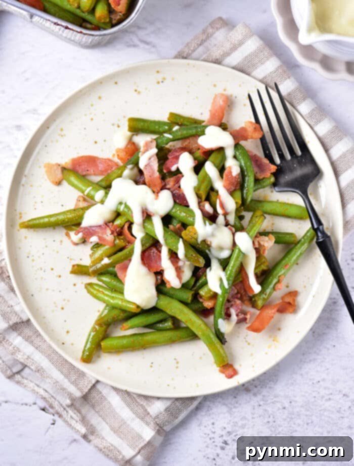 Green Bean Obsession 2 Crack Green Beans with crispy bacon bits and a creamy sauce, garnished and ready to be served as a delicious side dish.