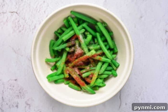 Green Bean Obsession 4 Close-up of baked green beans studded with crispy bacon bits, reflecting the dish's irresistible combination of textures and flavors.