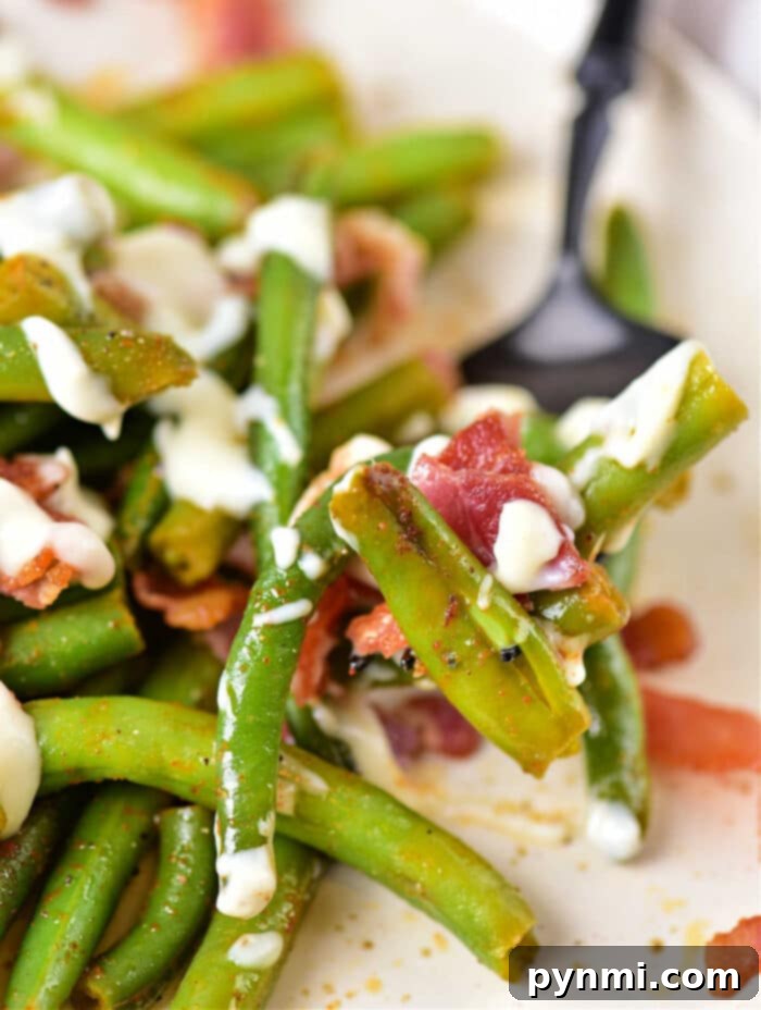 Green Bean Obsession 8 A close-up shot of the finished Crack Green Beans dish, showcasing the vibrant green beans, crispy bacon, and creamy sauce, garnished with fresh herbs.