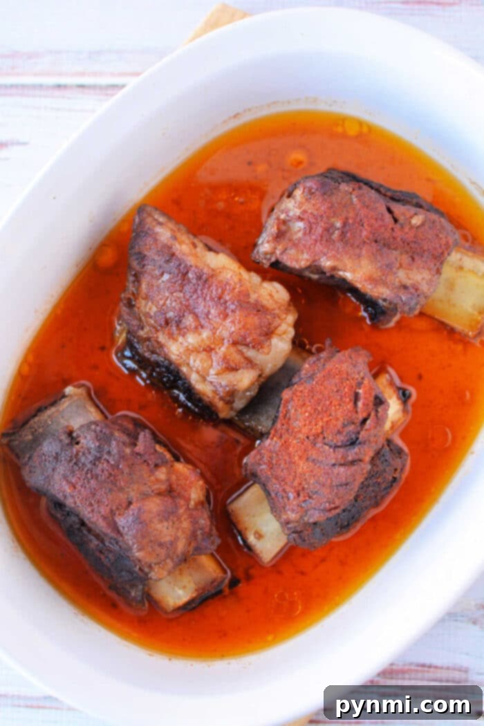 Fall-Off-The-Bone Oven Beef Ribs 10 Slow Cooked Beef Ribs Oven method showcased on a prepared tray.