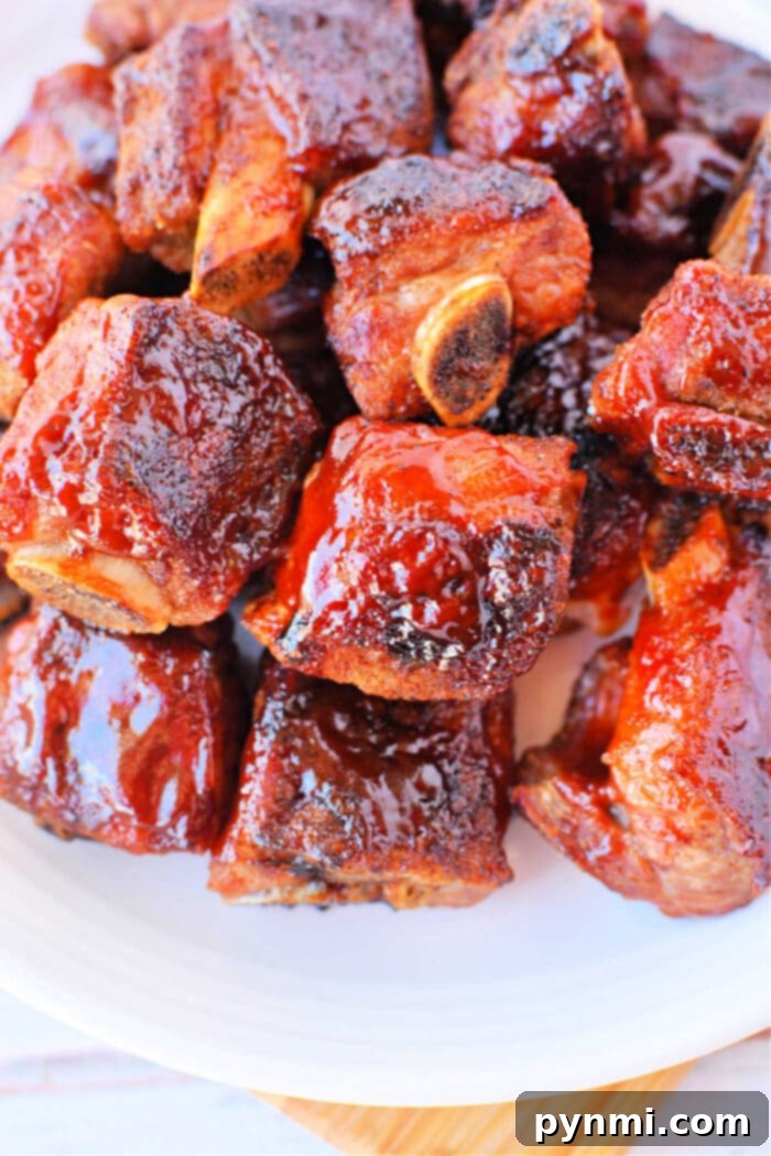 Tender Oven BBQ Riblets 2 A plate of perfectly glazed barbecue sauce riblets stacked together, showcasing the crispy, tender result of baked riblets in the oven.