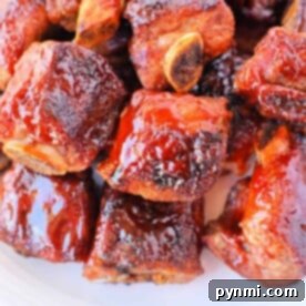 A plate of glazed barbecue sauce riblets stacked together, reminiscent of tender baked riblets in the oven.
