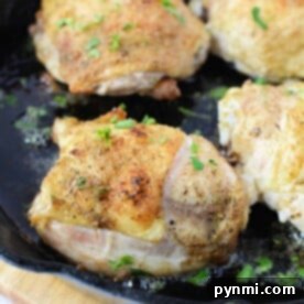 Four pieces of seasoned chicken are frying in a black cast iron skillet, garnished with chopped herbs. Wondering how long to bake these savory chicken thighs at 425 for a perfect finish?.