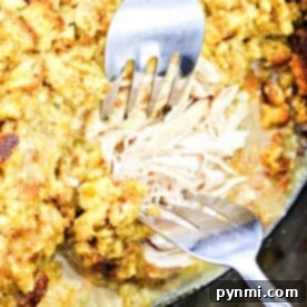 Two forks skillfully shred tender chicken bathed in a golden stuffing, all perfectly cooked in a Chicken and Stuffing Crockpot.