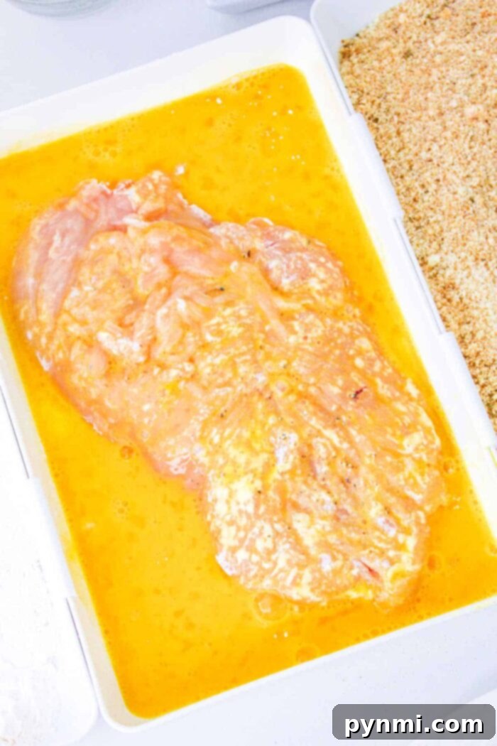 The Best Baking Time for Chicken Cutlets 4 Three shallow bowls arranged in a row, demonstrating the three-step breading process for chicken cutlets, from flour to egg wash to breadcrumbs.