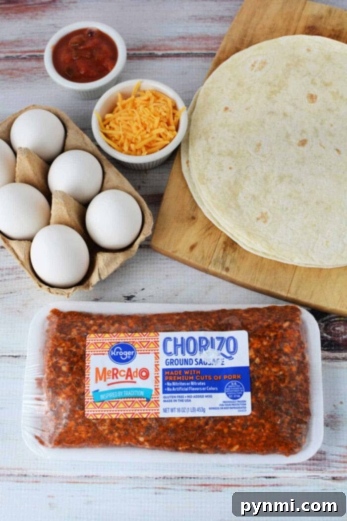 A wooden surface displays tortillas on a cutting board, eggs in a carton, grated cheddar cheese in a bowl, salsa in a small bowl, and a package of Kroger Mercado ground chorizo sausage—perfect ingredients for learning how to cook chorizo and eggs.