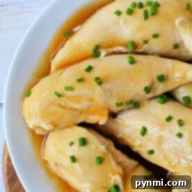 boiled chicken tenders with soy sauce and green onions, tender as ever, served on a pristine white plate. Perfect for those wondering how long to boil chicken tenders for a similarly succulent texture.